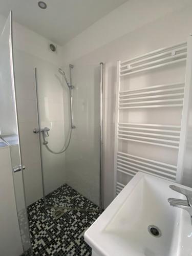 a white bathroom with a shower and a sink at Schöner Wohnen in Stuttgart Ost in Stuttgart