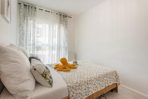 a stuffed teddy bear sitting on top of a bed at Apartament Fauna- blisko morza in Gdańsk