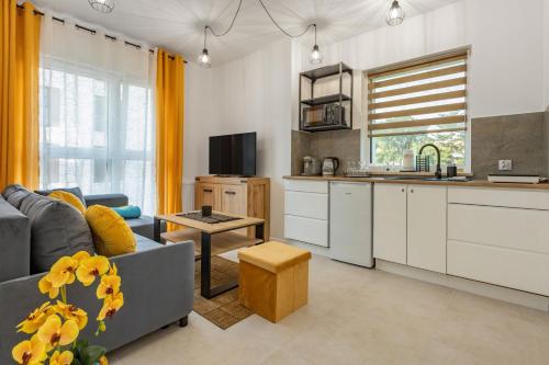 een keuken en een woonkamer met een bank en een tafel bij Apartament Fauna- blisko morza in Gdańsk