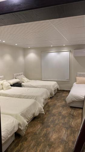 a group of beds in a room with a projection screen at إستراحة المزرعة in Abha