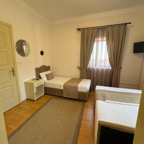 a hotel room with two beds and a window at Sözer Otel in Ayvalık