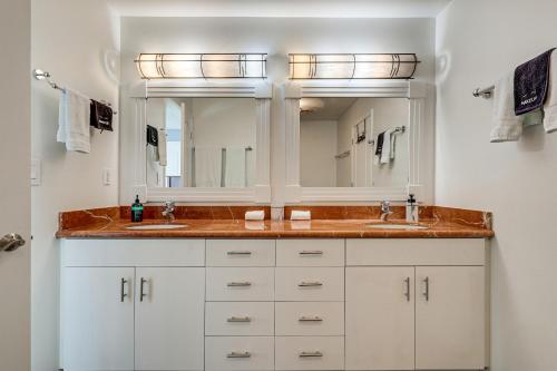 a bathroom with two sinks and two mirrors at Lakefront California Escape with Deck and Boat Dock! in Clearlake