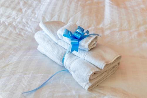 - deux serviettes pliées avec un arc bleu sur un lit dans l'établissement Sojourner’s Vista del Lago, à San Nicolás de Ibarra