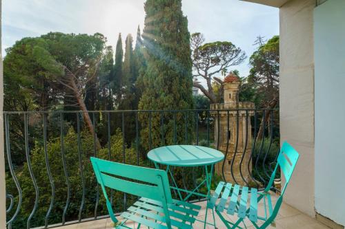 einen Tisch und Stühle auf einem Balkon mit einem Zaun in der Unterkunft Appartement Fabron - Welkeys in Nizza