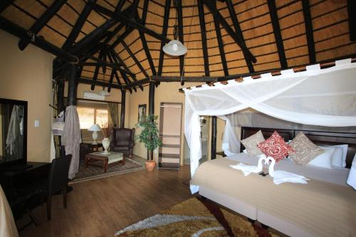 a bedroom with a bed with a canopy at Lapa Lange Game Lodge in Mariental