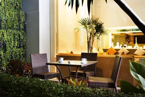 einen Tisch und Stühle auf einer Terrasse mit einem Sofa in der Unterkunft Citypoint Hotel in Bangkok