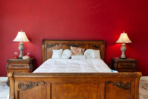 - une chambre avec un lit en bois et un mur rouge dans l'établissement Sojourner’s Vista del Lago, à San Nicolás de Ibarra