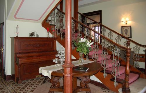a staircase leading up to a dining room with chairs and tables at Quinta de Villanueva in Colombres