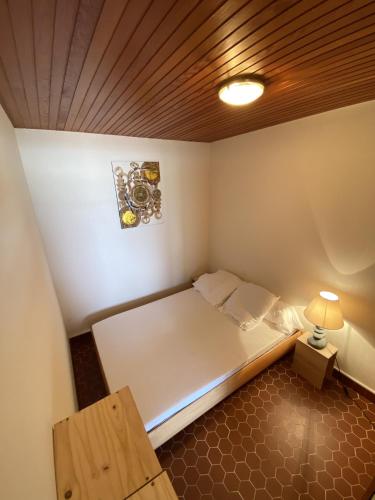 Cette petite chambre comprend un lit et une lampe. dans l'établissement Le Rivage, à Saint-Gilles-Croix-de-Vie