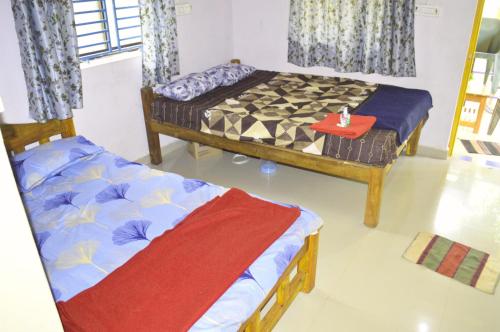 duas camas sentadas num quarto com em Appaji home stay em Gokarn