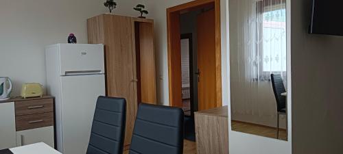 uma cozinha com um frigorífico, uma mesa e cadeiras em Ring Gasthaus em Zeltweg