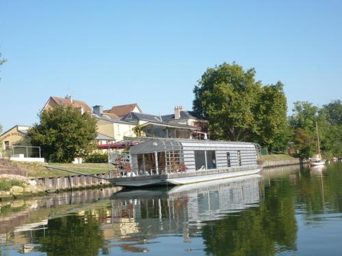 Ein Hausboot liegt auf einem Fluss vor Anker. in der Unterkunft Rooms with garden in Luckyhouse Maison Chatou Paris La Défense in Chatou