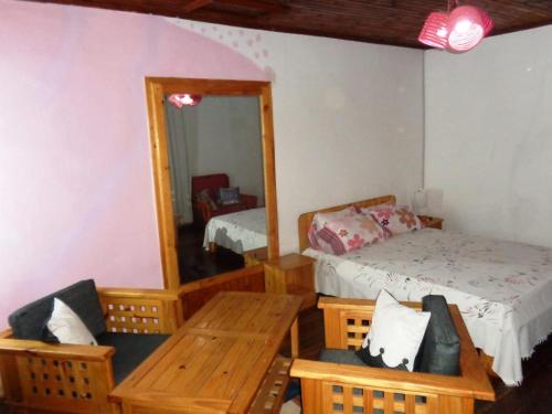 um quarto com uma cama, uma mesa e um espelho em At Home em Antsirabe