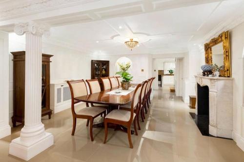 a dining room with a table and chairs and a fireplace at Entire Private Belgravia Mansion - Sleeps 12 in London