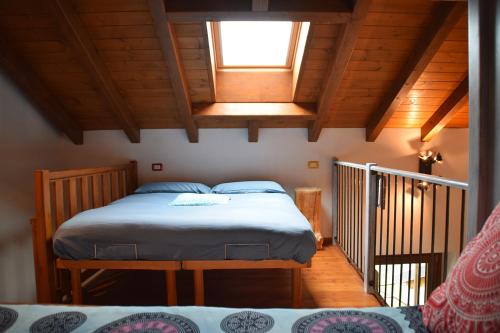 ein Schlafzimmer mit einem Bett in einem Zimmer mit Holzdecken in der Unterkunft La casa di nonna Anita in Abbadia Lariana