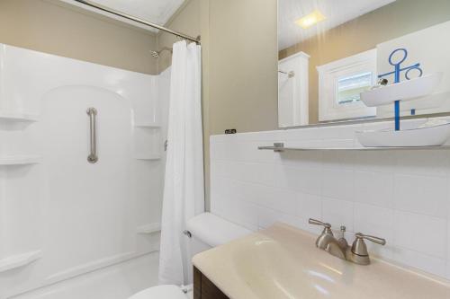 ein Badezimmer mit einem Waschbecken, einem WC und einem Spiegel in der Unterkunft The Beaches Guestrooms and Cottages in Wells