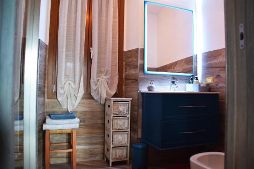 ein Badezimmer mit einem blauen Waschbecken und einem Spiegel in der Unterkunft La casa di nonna Anita in Abbadia Lariana