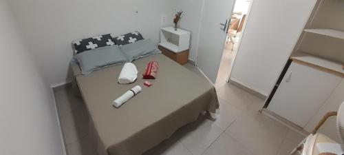 ein kleines Schlafzimmer mit einem Bett mit zwei Tassen darauf in der Unterkunft Casinha da paz in Jaú