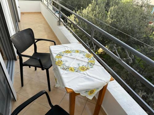 una mesa y sillas en un balcón con una placa. en Comfort Apartments Promenade, en Sarandë