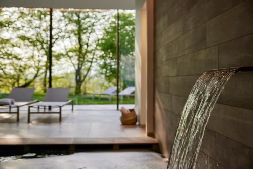 a water fountain in front of a building with chairs at CasaMartini Bed & Breakfast in Fonte