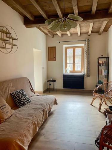 un salon avec un canapé et un ventilateur de plafond dans l'établissement La Maison de la Pépée by Longo Mai - Maison 6/8 personnes, à Groslée