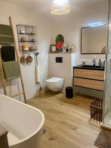 une salle de bain avec une baignoire, des toilettes et un lavabo dans l'établissement La Maison de la Pépée by Longo Mai - Maison 6/8 personnes, à Groslée