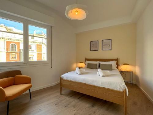 een slaapkamer met een bed, een stoel en een raam bij Stay U-nique Apartments Gaudi I in Barcelona