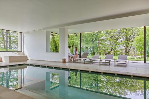 a house with a swimming pool and a woman sitting on a couch at CasaMartini Bed & Breakfast in Fonte