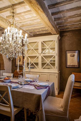 a dining room with a table and a chandelier at Podere Cavalbianco in Ciggiano