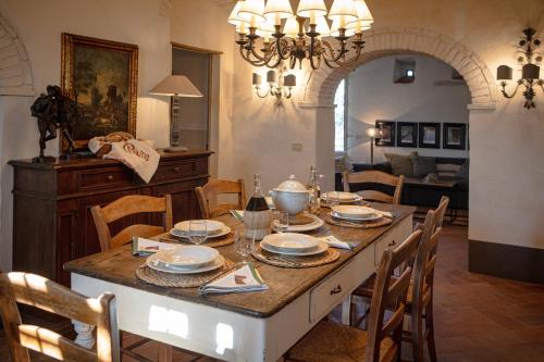 a dining room with a table with plates and dishes on it at Podere Cavalbianco in Ciggiano