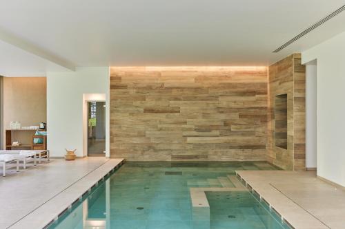 a swimming pool in a house with a stone wall at CasaMartini Bed & Breakfast in Fonte