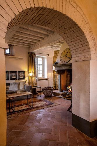 a living room with a fireplace and a clock at Podere Cavalbianco in Ciggiano