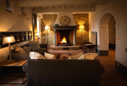 a living room with a couch and a fireplace with a clock at Podere Cavalbianco in Ciggiano