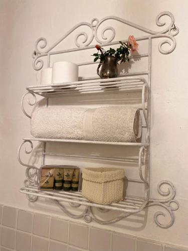 a bathroom shelf with towels and a vase with flowers at Podere Cavalbianco in Ciggiano