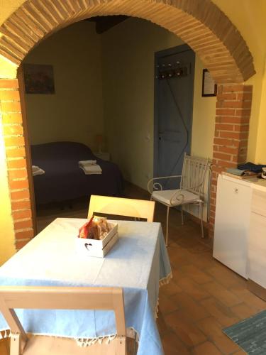 a living room with a table and a bed at Casale del Rosmarino - Monolocale Melograno in Montefiascone