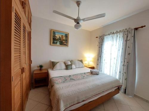 een slaapkamer met een bed en een plafondventilator bij Tamarindo in Bayahibe