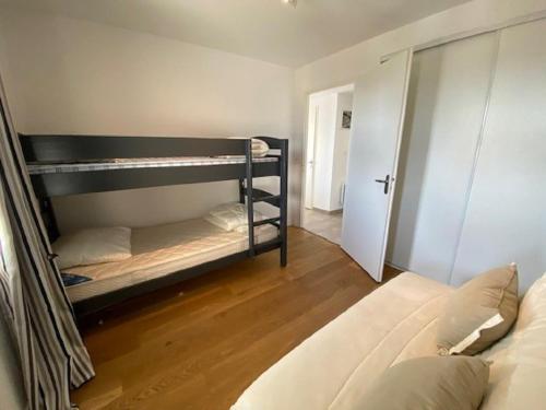 une chambre avec deux lits superposés et un canapé dans l'établissement Le Banc de Sable, à Saint-Gilles-Croix-de-Vie