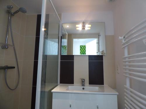 une salle de bain avec un lavabo et un miroir dans l'établissement Le Banc de Sable, à Saint-Gilles-Croix-de-Vie