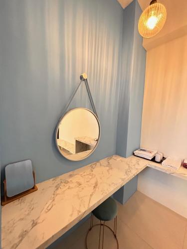 a mirror hanging on a wall next to a desk at 台東樂典民宿 國旅優惠 近火車站 寵物友善 停車方便 in Taitung City