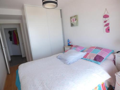 une chambre avec un lit blanc avec deux oreillers dans l'établissement Le Sable doux, à Saint-Gilles-Croix-de-Vie