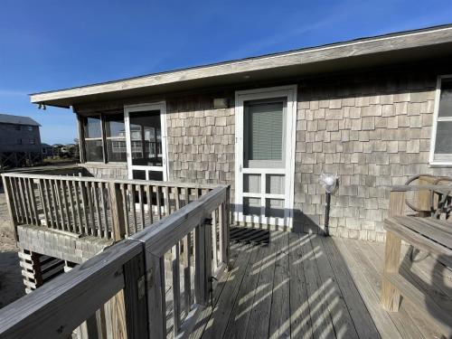 a house with a porch and a deck at SEA ESCAPE cottage in Buxton