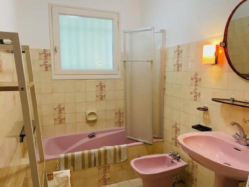 a bathroom with a pink tub and a sink at Maison au calme et a 2 pas de la plage in Saint-Gilles-Croix-de-Vie