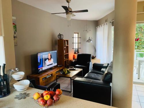 a living room with a television and a bowl of fruit at Beachfront apartment in Ballito! Casablanca in Ballito