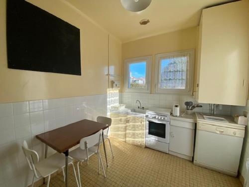 - une cuisine avec une table, une table et des chaises dans l'établissement La Sauvageonne, à Saint-Gilles-Croix-de-Vie