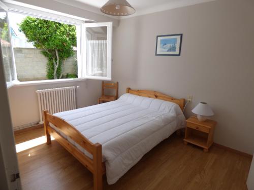 une chambre avec un grand lit et une fenêtre dans l'établissement L'Atlantique, à Saint-Gilles-Croix-de-Vie