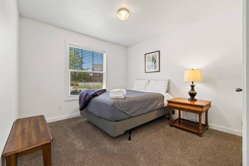 梅里迪安的住宿－Peaceful & Comfy Single Level Town Home (90)，一间卧室配有一张床、一张桌子和一个窗户。