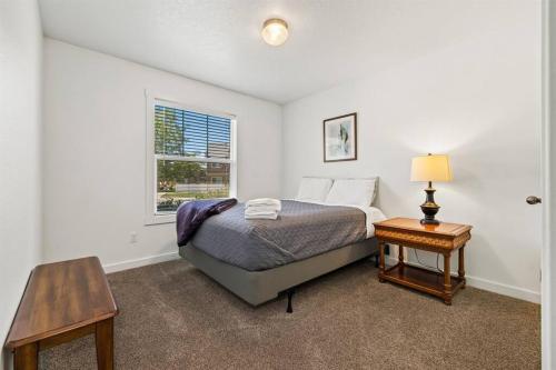 Un dormitorio con una cama y una mesa y una ventana. en Peaceful & Comfy Single Level Town Home (90), en Meridian