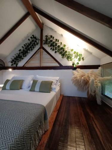 a bedroom with a bed with plants on the wall at Refugio Cabaña San Carlos Antioquía C in San Carlos