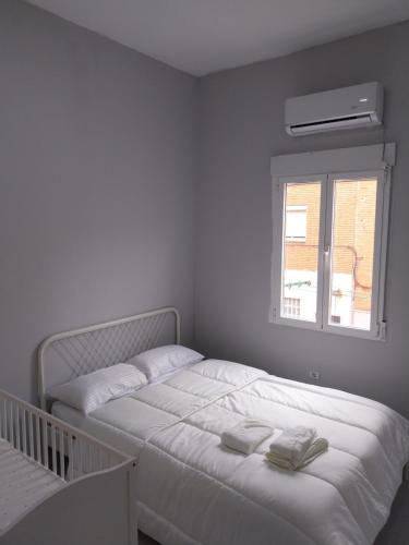 a white bedroom with a bed and a window at La Iniciativa 2: La luz y El camino in Madrid
