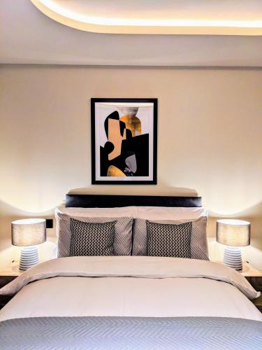ein Schlafzimmer mit einem Bett mit einem Bild darüber in der Unterkunft Soho Mandarin in London